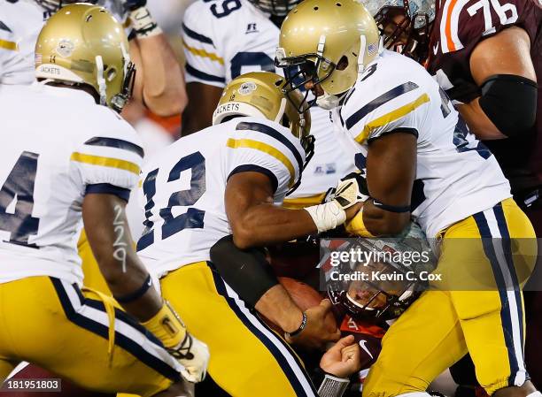 Logan Thomas of the Virginia Tech Hokies drives for yardage against Demond Smith and Domonique Noble of the Georgia Tech Yellow Jackets at Bobby Dodd...