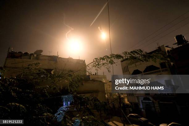 Flares launched by the Israeli forces light up the sky above Khan Yunis in the southern Gaza Strip late on December 3, 2023. Israel expanded its...