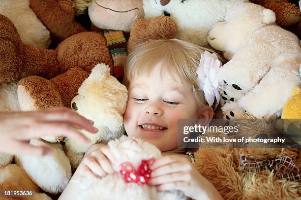 happy little girl among a thousand of teddy bears - pony play stock-fotos und bilder