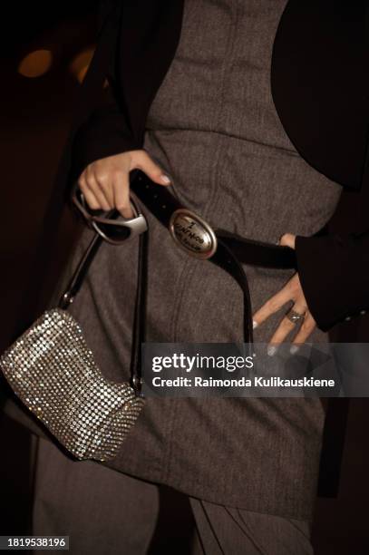 Guest wears grey pants, matching long top with a belt, black cropped jacket and mini bag with rhinestones during the Tashkent Fashion Week 2023 on...