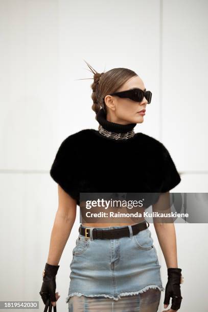 Guest wears long skirt part blue denim, part white and blue silk with a black belt, black leather gloves from Dolce & Gabbana, black big fur bag,...