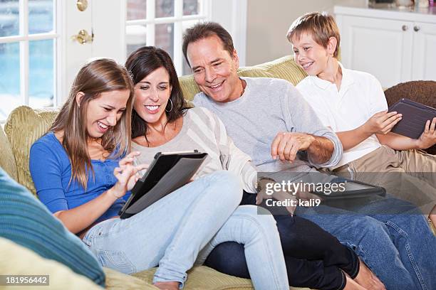 famiglia sul divano, utilizzando tablet digitale - girl 11 12 laughing close up foto e immagini stock