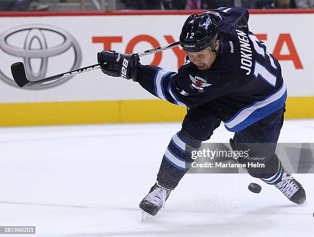 Olli Jokinen of the Winnipeg Jets misses the puck as he attempts to score against the Boston Bruins in second period action during an NHL preseason...