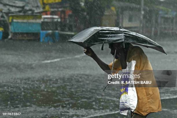 Pedestrian wades through a flooded street after heavy rains in Chennai on December 4, 2023. Cyclone Michuang is expected to make landfall on December...