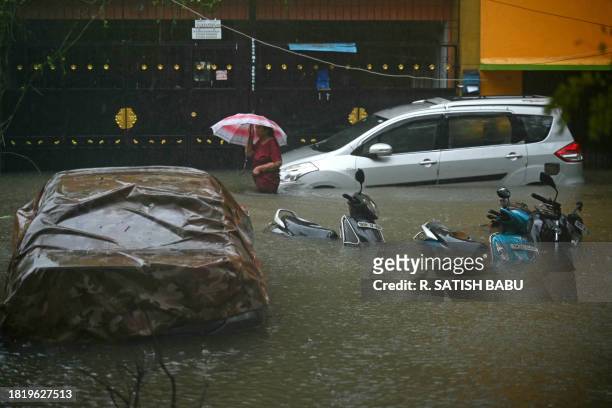 Resident wades through a flooded street after heavy rains in Chennai on December 4, 2023. Cyclone Michuang is expected to make landfall on December 5...