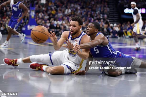 Stephen Curry of the Golden State Warriors competes for a loose ball against De'Aaron Fox of the Sacramento Kings in the second quarter during the...