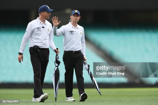 Umpires signal to players that the covers will be placed on the pitch during the Sheffield Shield match between New South Wales and Tasmania at SCG,...
