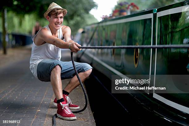 young man pulling rope of canal canal boat - arrastar imagens e fotografias de stock