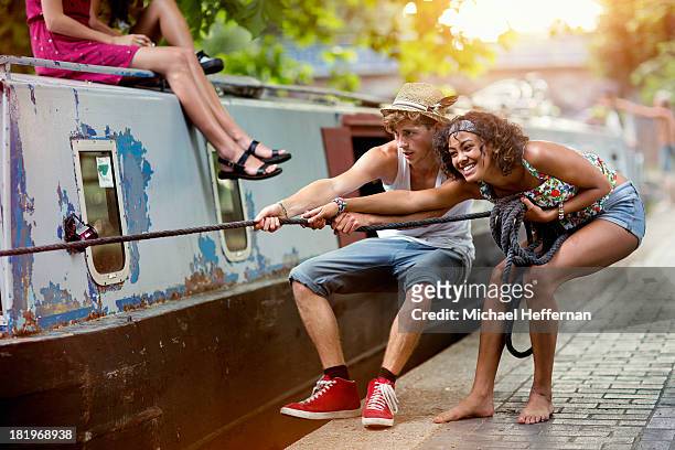 two young people pulling on canal boat rope - to pull together stock pictures, royalty-free photos & images