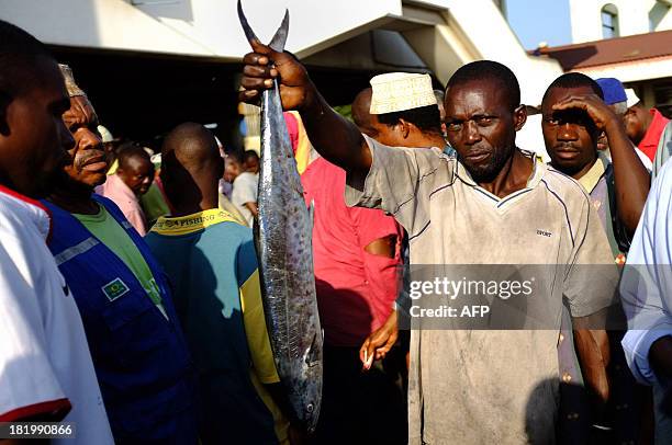 Fisherman John Peter auctions off a small kingfish on September 27, 2013 in Dar es Salaam. A kingfish of this size may fetch up to 20000 Tanzanian...