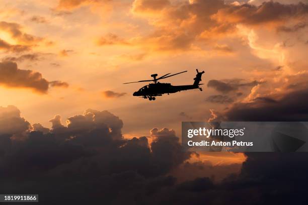 military helicopter on the background of the sunset sky - attack helicopter stock pictures, royalty-free photos & images