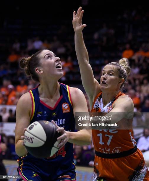 Isabelle Bourne of the Lightning drives to the basket past Sami Whitcomb of the Fire during the WNBL match between Townsville Fire and Adelaide...