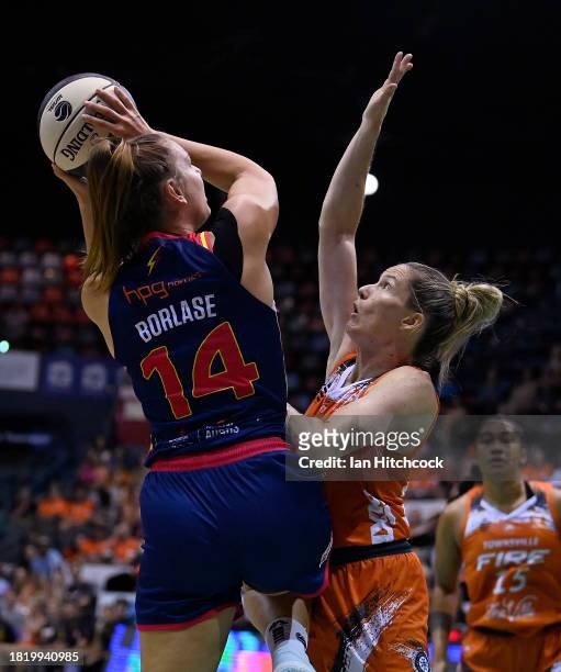 Isobel Borlase of the Lightning drives to the basket over Sami Whitcomb of the Fire during the WNBL match between Townsville Fire and Adelaide...