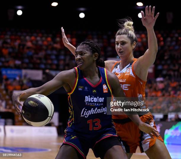 Jocelyn Willoughby of the Lightning attempts to get past Cassandra Brown of the Fire during the WNBL match between Townsville Fire and Adelaide...