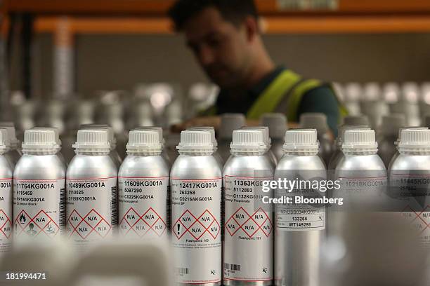 An employee removes a canister of flavoring from the shelf at the Treatt Plc flavoring and fragrances factory in Bury St Edmunds, U.K., on Wednesday,...
