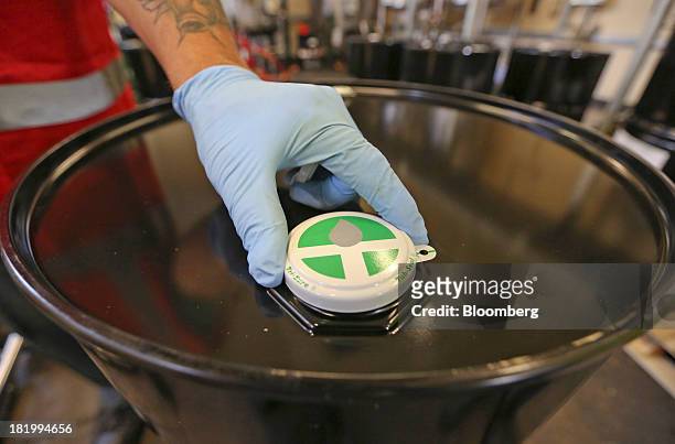An employee places a seal on to a flavoring container drum at the Treatt Plc factory in Bury St Edmunds, U.K., on Wednesday, Sept. 25, 2013. Treatt...