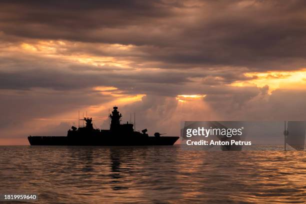 warship at dramatic sunset in the sea - military convoy stock pictures, royalty-free photos & images