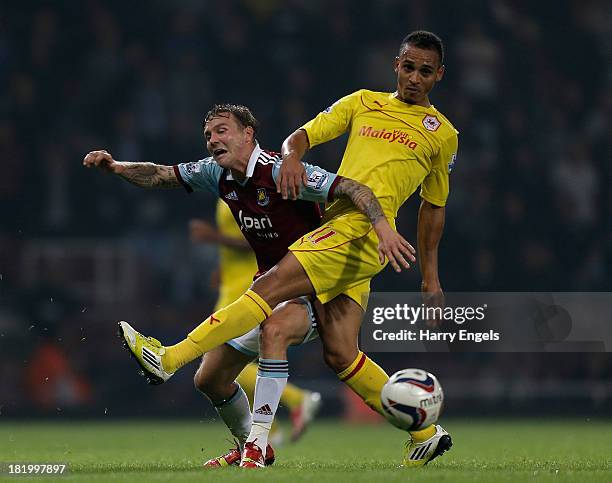 Matt Taylor of West Ham is tackled by Peter Odemwingie of Cardiff City during the Capital One Cup third round match between West Ham United and...