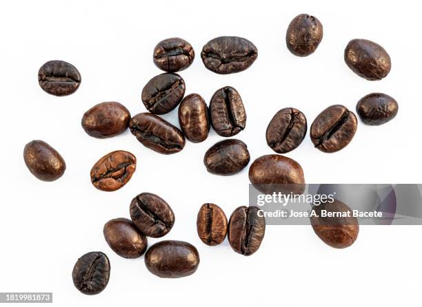 roasted robusta coffee beans scattered on a white background. - geröstete kaffeebohne stock-fotos und bilder