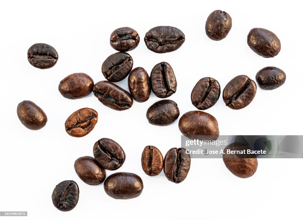 Roasted Robusta coffee beans scattered on a white background.