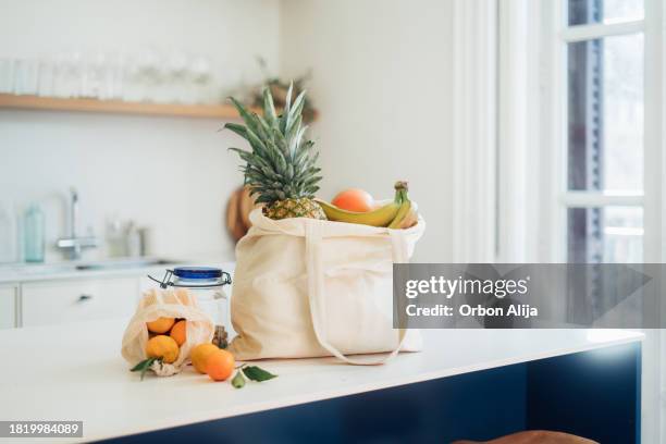 shopping bag with vegetables and fruits on coutertop - mesh bag stock pictures, royalty-free photos & images