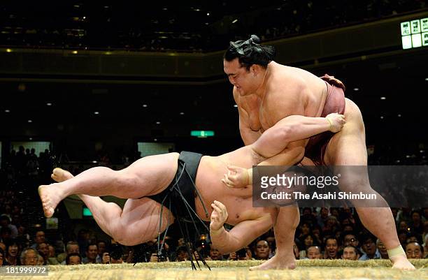 Ozeki Kisenosato throws Mongolian yokozuna Harumafuji, whose real name is Altangadasyn Khuchitbaatar during day twelve of the Grand Sumo Autumn...