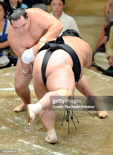 Mongolian ozeki Kakuryu whose real name is Mangaljalavyn Anand throws Toyohibiki during day twelve of the Grand Sumo Autumn Tournament at Ryogoku...