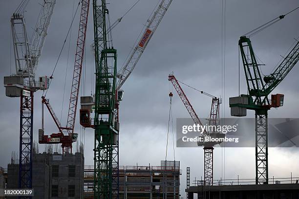 Construction cranes stand above a new commercial real estate development near Kings Cross rail station in London, U.K., on Thursday, Sept. 26, 2013....