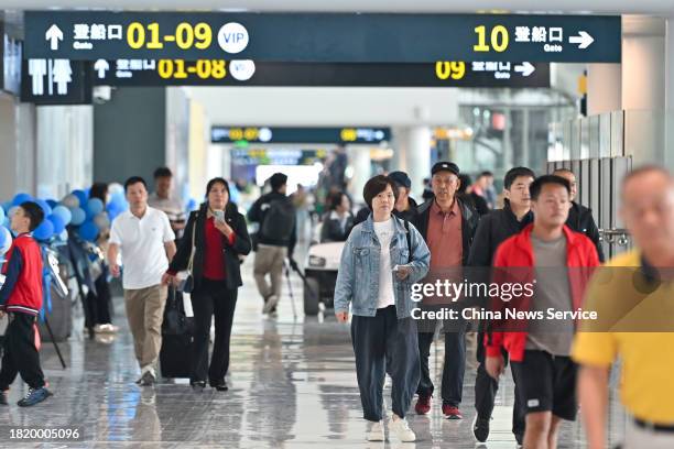 Travellers prepare to board a ship at the Xinhai ro-ro passenger terminal on November 29, 2023 in Haikou, Hainan Province of China. The new ferry...