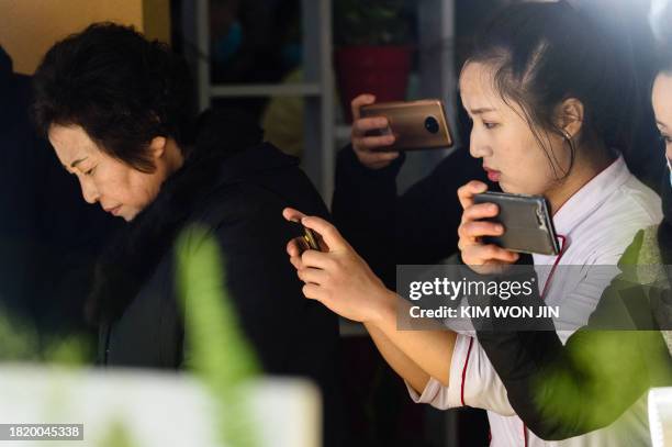 Visitors take photos of various kinds of kimchi exhibited at the National Kimchi Show at the Food Festival House on Ryomyong Street, Pyongyang on...