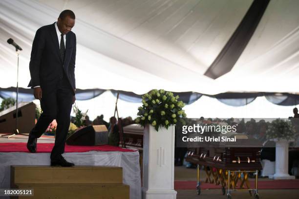 Kenyan President Uhuru Kenyatta walks down from the stage past his nephew's coffin at the funeral service for his nephew Mbugua Mwangi and his...