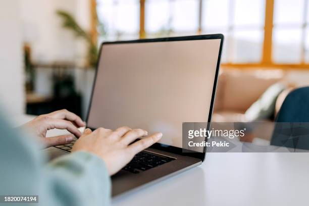 close up shot of woman using laptop with blank screen at home - blank screen stock pictures, royalty-free photos & images