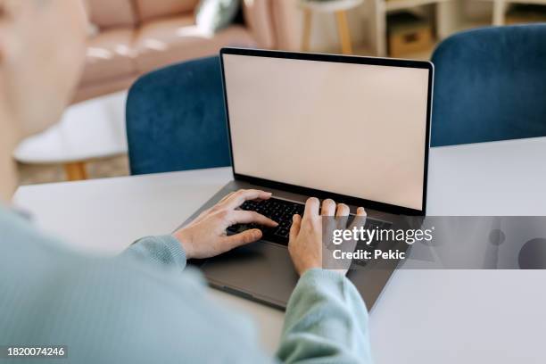 close up shot of woman using laptop with blank screen at home - blank screen stock pictures, royalty-free photos & images