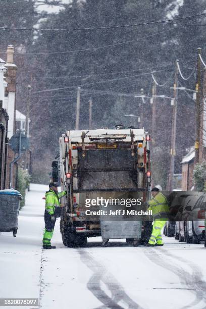 Bin men empty bin during a snow shower on November 29, 2023 in Ballater Scotland. On Tuesday, the Met Office issued a warning for snow and ice from...