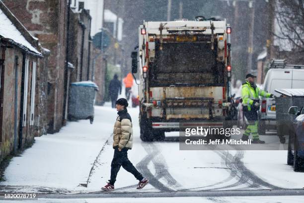 Bin men empty bin during a snow shower on November 29, 2023 in Ballater Scotland. On Tuesday, the Met Office issued a warning for snow and ice from...