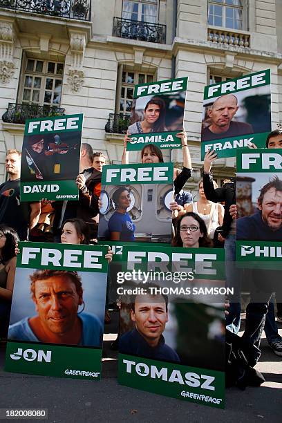 Greenpeace activists protest on September 27, 2013 in front of the Russian embassy in Paris, with signs calling for the release of activists from...