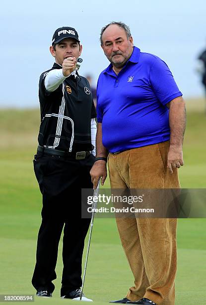 Louis Oosthuizen of South Africa helps his amateur partner Andrew Chandler of England The Managing Director of ISM the sports management company line...