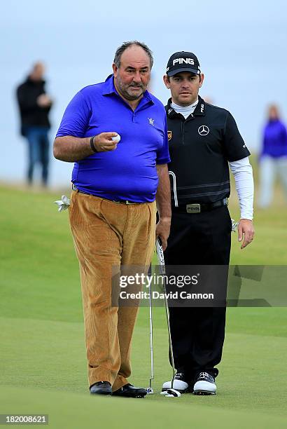 Louis Oosthuizen of South Africa helps his amateur partner Andrew Chandler of England The Managing Director of ISM the sports management company line...