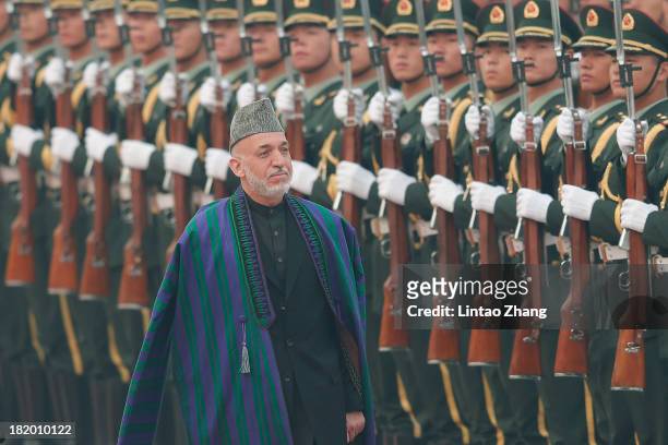 Chinese President Xi Jinpin accompanies Afghan President Hamid Karzai to view an honour guard during a welcoming ceremony outside the Great Hall of...