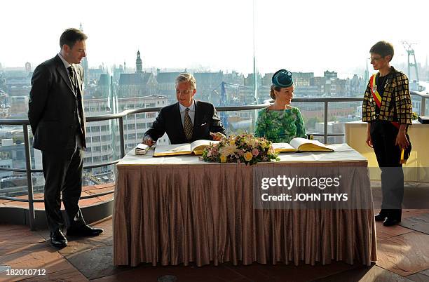 Queen Mathilde and King Philippe of Belgium sign a register as Antwerp's mayor Bart De Wever and Antwerp's province governor Cathy Berx look on...