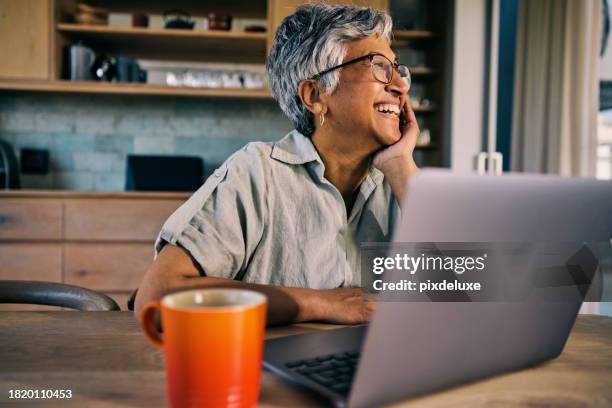 smiling generation x african-american woman enjoying retirement while using laptop in a sunny home interior - paparazzi x posed stock pictures, royalty-free photos & images