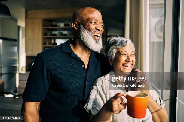 afroamerikanisches reifes paar, das voller optimismus aus dem fenster seines hauses schaut. - person gemischter abstammung stock-fotos und bilder