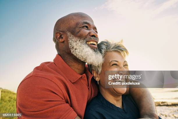 pareja afroamericana madura activa que disfruta de la jubilación y de la compañía del otro en la playa. - etnia fotografías e imágenes de stock