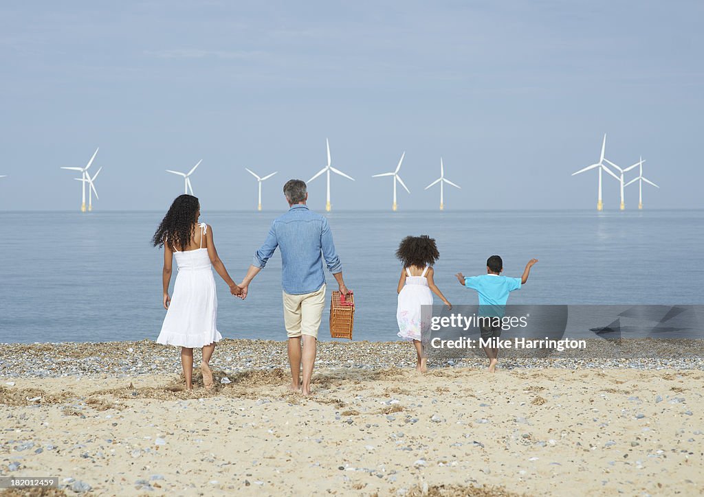 Family on beach walking towards sea.