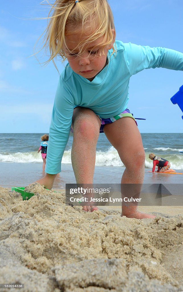 Girl Playing in Beach Sand