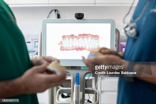 dentists in the dental clinic look at the screen with a denture scanner - dentistry stock pictures, royalty-free photos & images