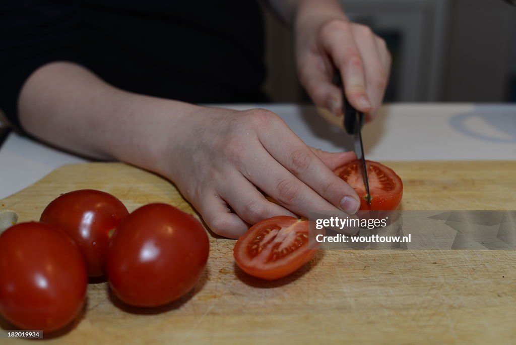 Boy cuts tomatoes