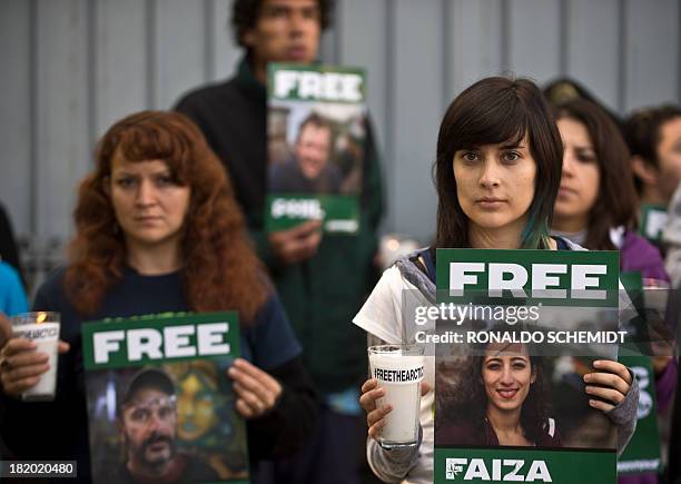 Greenpeace activists protest on September 27, 2013 in front of the Russian embassy in Mexico City, with signs calling for the release of activists...