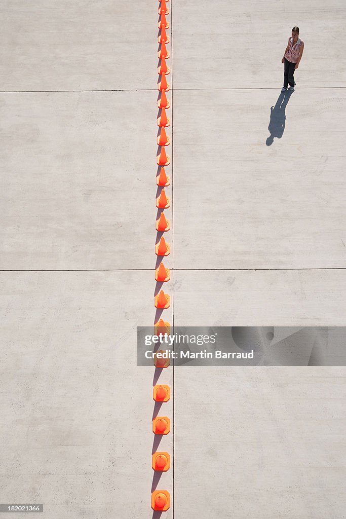 Woman looking at row of traffic cones