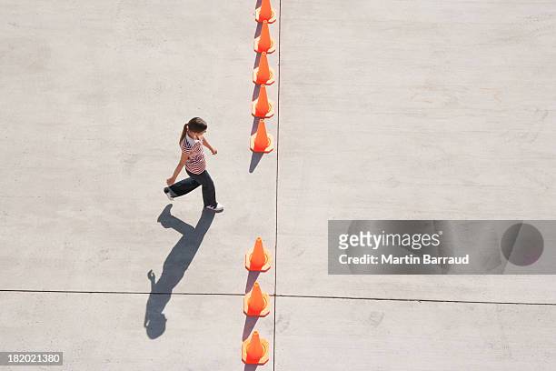 woman walking through opening in row of traffic cones - detour stock pictures, royalty-free photos & images